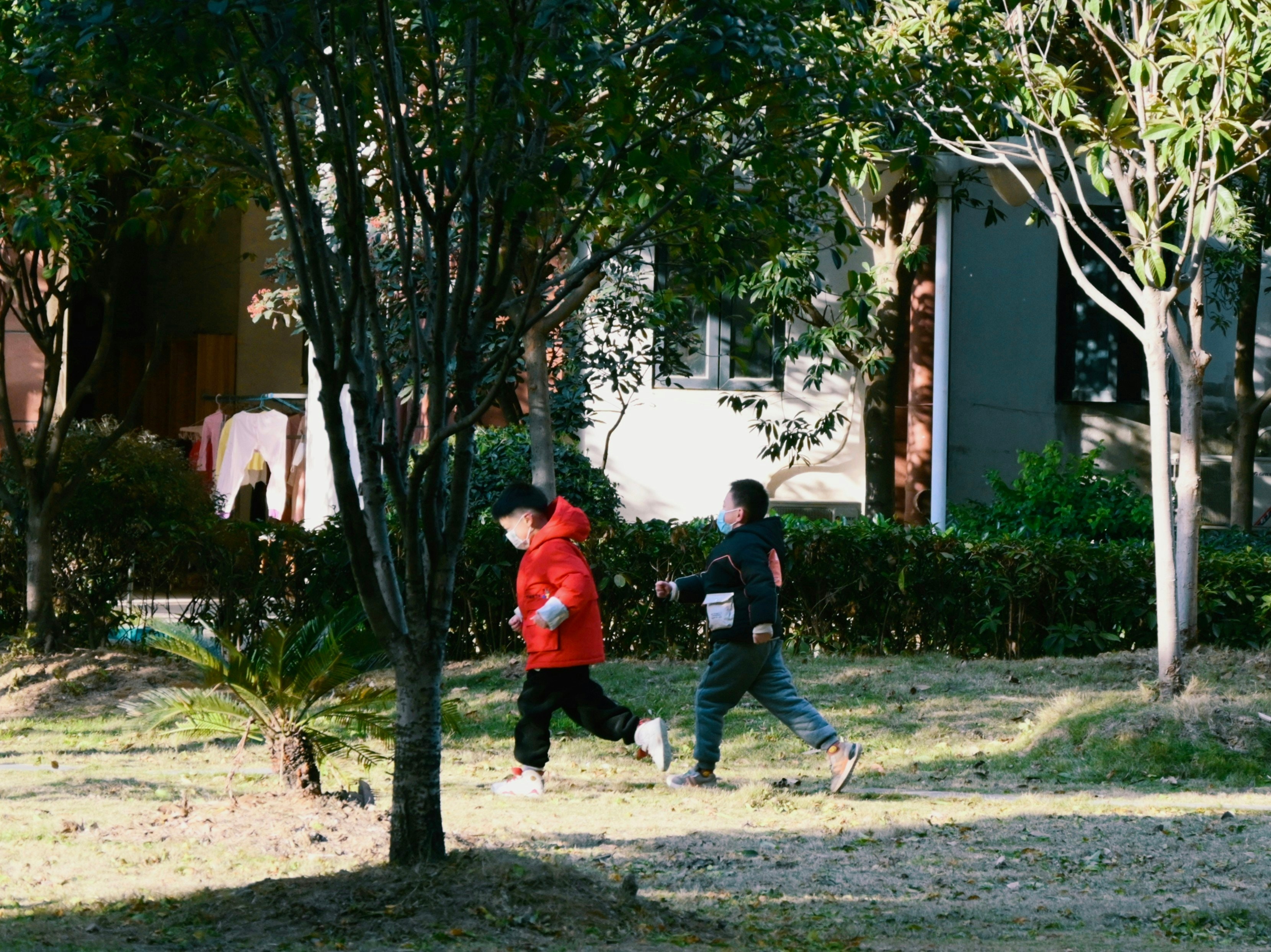 A few children are running in the field.