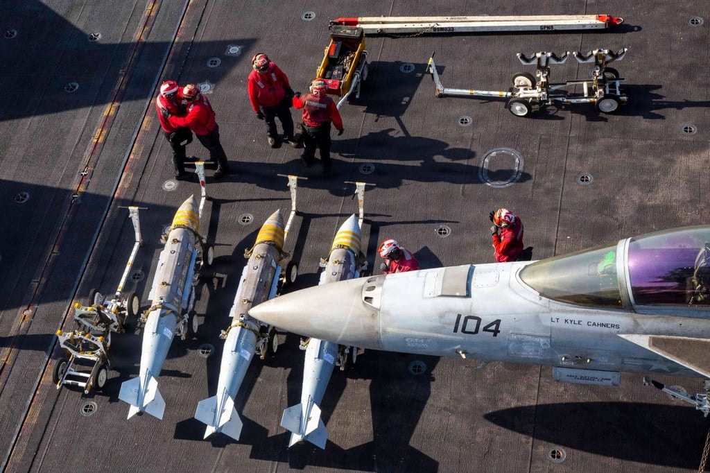Marineros estadounidenses se preparan para cargar armamento en un F/A-18F Super Hornet a bordo del USS Abraham Lincoln. Foto: Armada de los Estados Unidos vía AP.