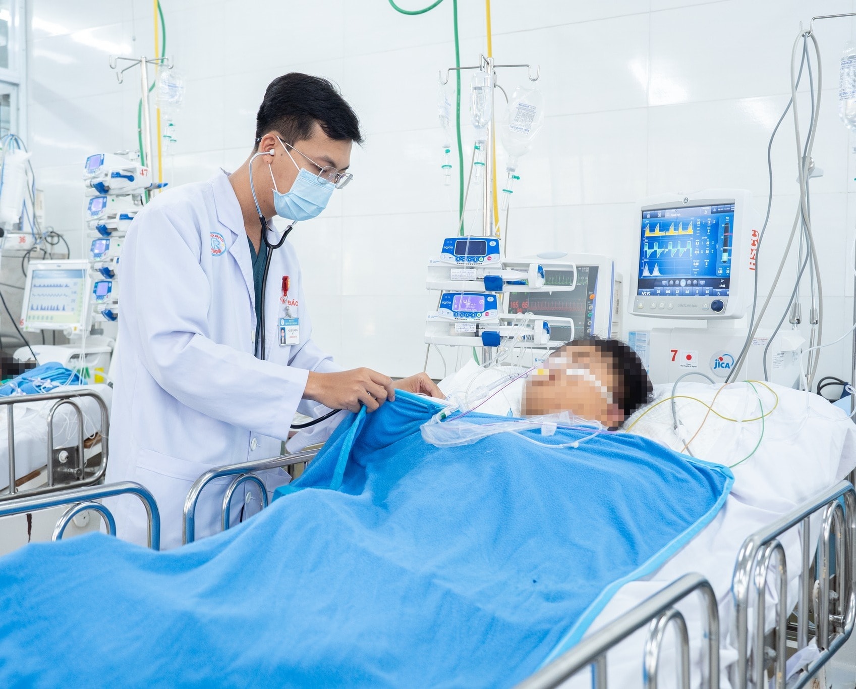 BS Nguyễn Xuân Bách - khoa Hồi sức Cấp cứu bệnh viện Chợ Rẫy đang thăm khám BN N.T.H, sinh năm 2007 (ngụ tỉnh Lâm Đồng) sau phẫu thuật. Ảnh: BVCC