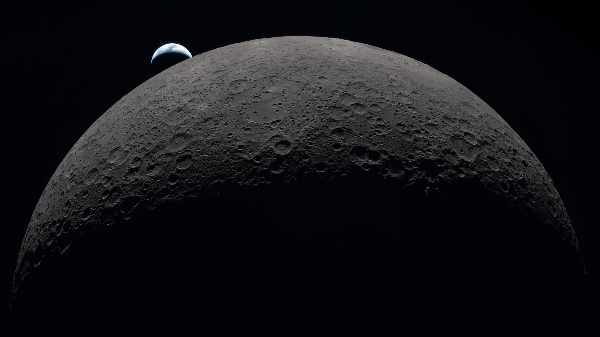 This image, taken from outside the Moon, shows tiny Earth floating above the giant Moon.