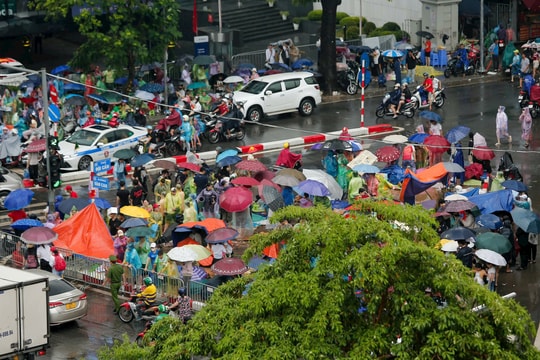 Người dân đội mưa ngồi chờ xem diễu binh