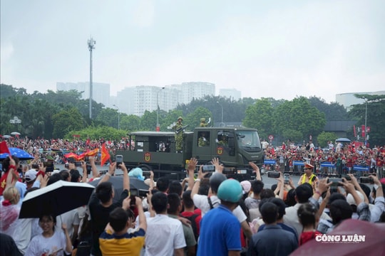 Người dân đội mưa tiễn đoàn xe diễu binh trong tiếng pháo tay vang dội