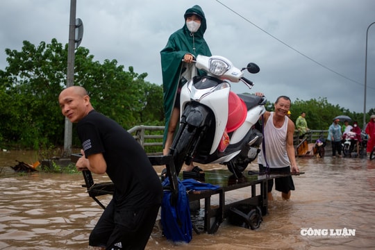 Đường ngập sâu cả mét, người dân chen nhau thuê kéo xe qua đường