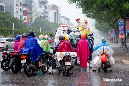 Cảnh sát giao thông hỗ trợ người dân di chuyển qua vùng ngập