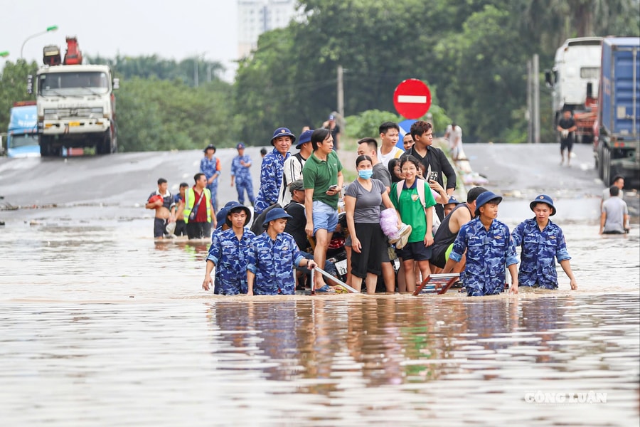 Cảnh sát biển ngâm mình dìu dân vượt qua điểm ngập sâu gần 1m ở Hà Nội